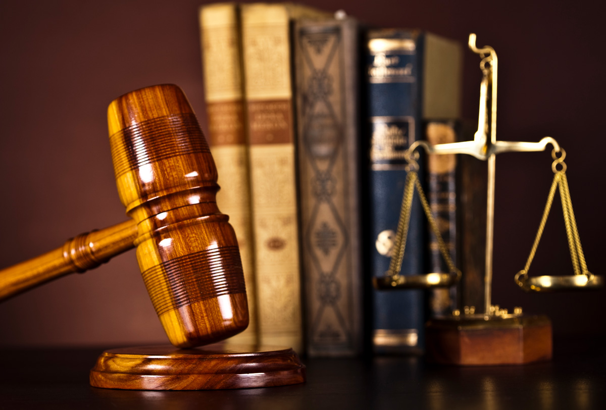Mazo, libros de derecho y balanza de la justicia en un despacho